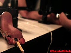 rough lezdom domina engages with her submissive's clit in a bondage session