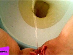my shaved pierced pussy releasing a stream of pee in the bathroom