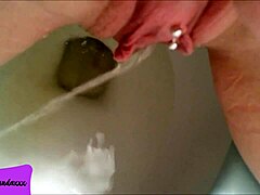my shaved pierced pussy releasing a stream of pee in the bathroom